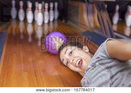 Young Woman Sliding Down A Bowling Alley