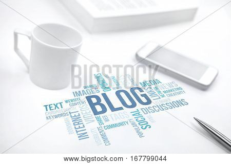 Blog concept word cloud print document smartphone book pen and coffee cup. Blue toned