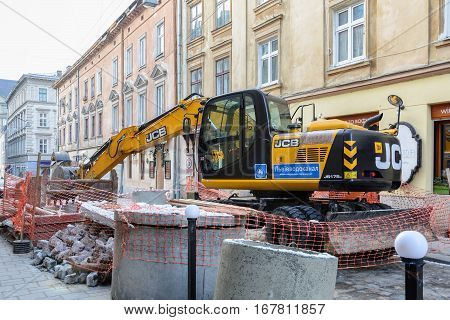 Ukraine Lviv - December 17 2016: Repair of the aqueduct in the city center of Lviv on the narrow street. Construction machinery. Excavation work at the construction site.