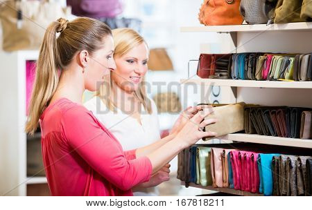 Female customers in store shopping looking for wallets and purses