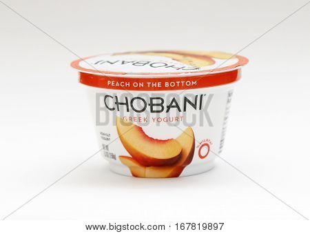 New York January 23 2017: A container of peach Chobani greek yogurt stands against white background.