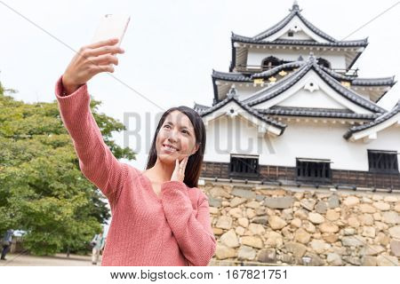 Asian Woman taking selfie by mobile phone in Hikone Castle
