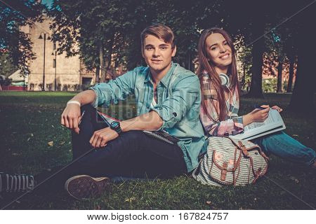 Cheerful couple with studying in green park