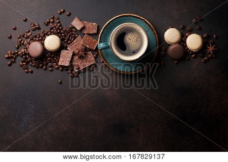 Coffee cup, beans, chocolate and macaroons on old kitchen table. Top view with copyspace for your text 