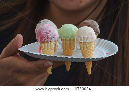 colorful ice cream cones in hands in Thai market