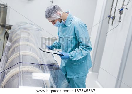 Scientist Making Notes About Machine
