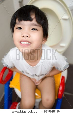 children Asian girl sitting on toilet . .
