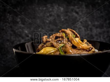 Asian rice with beef meat and vegetagles on dark background