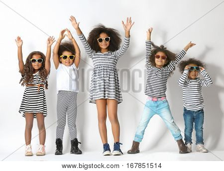 Five cute African girls in striped clothes on white background