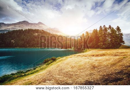 Great view of the azure pond Champfer in alpine valley. Picturesque and gorgeous scene. Location Swiss alps, Silvaplana village. Europe. Retro and vintage style. Instagram toning effect. Beauty world.