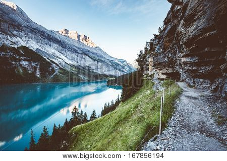 Panorama of the azure pond Oeschinensee. Popular tourist attraction. Picturesque and gorgeous scene. Location Swiss alps, Kandersteg, Bernese Oberland, Europe. Instagram toning effect. Beauty world.
