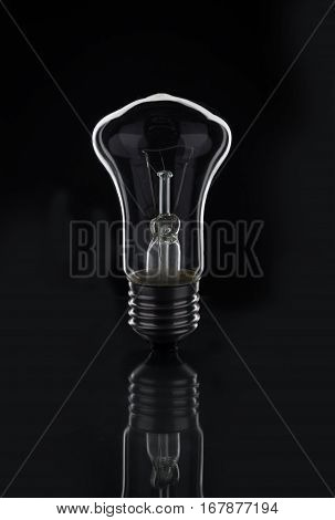 Light bulb on black background. Contrast. Concept.