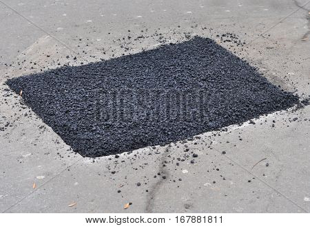 Close up on asphalt road repair. Repair pavement and laying new asphalt patching method outdoors.