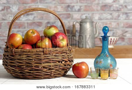 Basket with beautiful apples and carafe of calvados