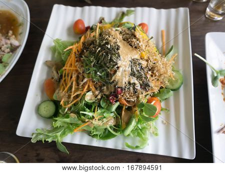 mixed vegetable salad with tomatoes onions and feta cheese in a white bowl
