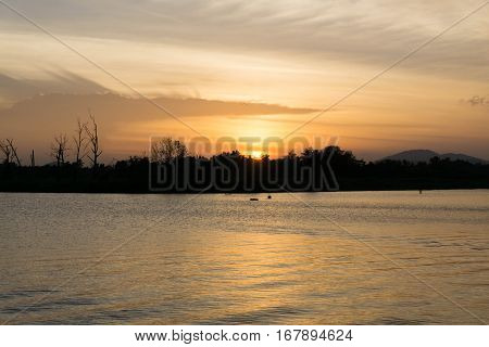 The sun went down behind the forest above the water cloudy / area Bueng Khun sea /SuratthaniThailand