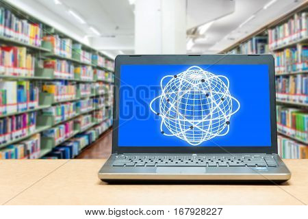 Laptop with blank screen on table with blur bookshelf at libraly Education and technology concept.