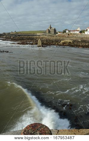 A wave crashes against the breakwater at St. Monans harbour