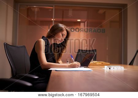 Young Asian businesswoman working alone late in an office