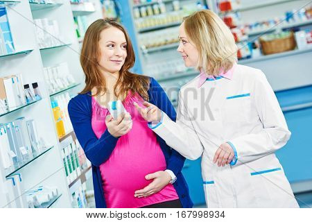 pregnancy and pharmaceutics. pharmaceutist with pregnant at pharmacy store