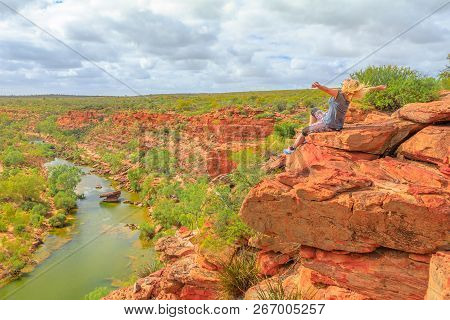 Happy Blonde Woman With Open Arms On Red Sandstone Rock At Hawks Head Lookout Over Murchison River I