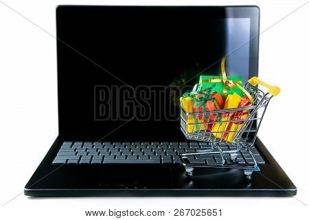 Ciber Monday Concept - Trolley Cart With Christmas Presents On Notebook, Isolated On White