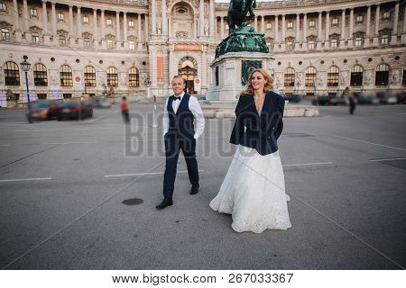 Groom Gives Jaket To His Bride. They Walk Into The City