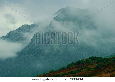 Blurred Rainy Landscape In The Caucasus, Overcast Sky, Mountain Peaks And Green Slopes