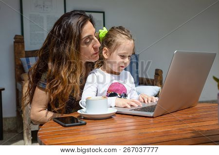 Girl And Mother Watching Notebook Computer