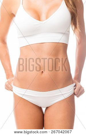 Midsection Of Titillating Woman Wearing White Undergarments In Studio