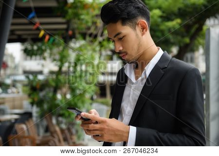 Young Smart Arab Asian Businessman Check Project Plan And Chat With Coworkers On Mobile Smartphone B