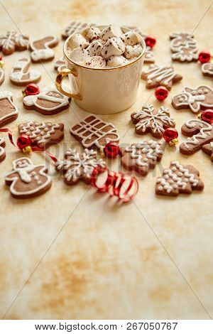 Cup of hot chocolate with tasety marshmellows. Fresh baked Christmas shaped gingerbread cookies on sides. With Xmas decorations. View from above.