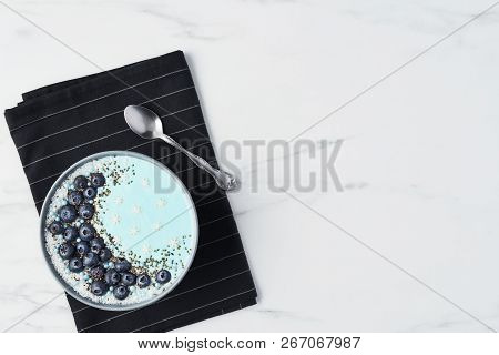 Top View Of Blue Yogurt Smoothie Bowl Made With Blueberry, Coconut Flour, Chia Seeds And Sugar Pearl