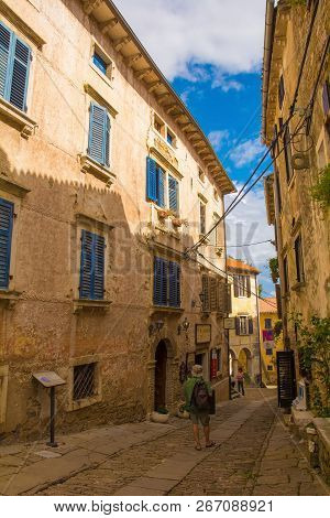 Groznjan, Croatia - September 3rd 2018. Tourists Walk Down A Quaint Street In The Hill Village Of Gr