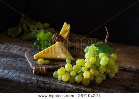 Slate Board With Various Cheese And A Glass Of Red Rose Wine. Gouda, Masdaam, Cheddar And Grapes On 