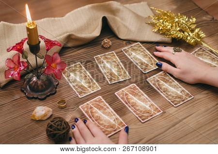 Tarot Cards And Hands Of Fortune Teller On Wooden Table Background.