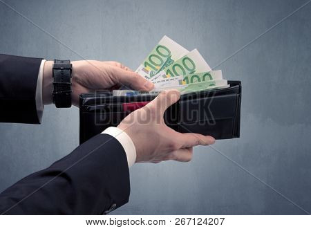 Businessman's hand in suit takes out eruo from his wallet