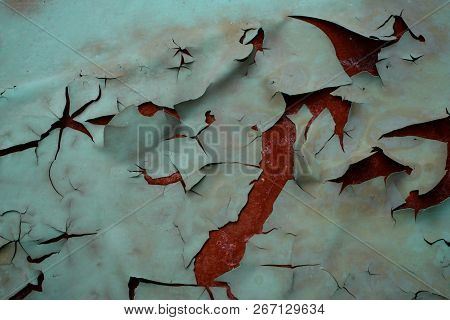 Background Of Peeled Off And Discolored Green Paint And A Rusty Surface Under It.