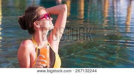 Beautiful Woman With Tropical Cocktail In The Pool