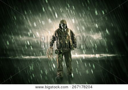 Terrorist in a stormy space with gas mask on his hand and weapons on his arm