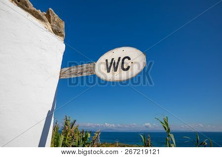 Wood Signpost With Wc Text And Ocean On The Horizo