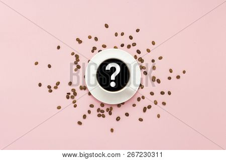 White Cup With Black Coffee, Grains Of Coffee, On A Pink Background. Question Mark. Flat Lay, Top Vi