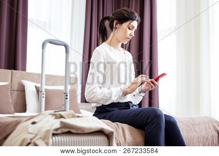 Serious Young Woman Sitting On The Hotel Bed