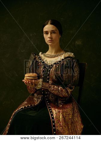 Portrait Of A Girl Wearing A Princess Or Countess Dress Over Dark Studio. Portrait With Burger