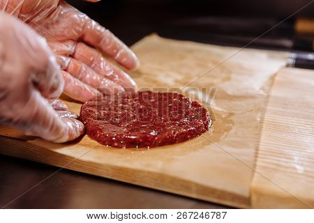 Chef Making Burger. Chef In Food Gloves Makes Cutlet. Cutlets Are Leveled In Steel Ring In An Even M
