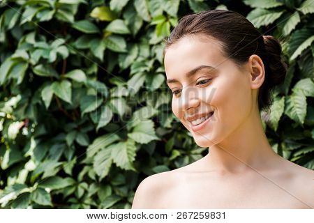 Smiling Young Woman With Green Leaves At Background