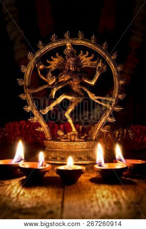 Maha Shivaratri or Diwali concept - Shiva Nataraja figurine with Diwali lights oil ghee candles, India