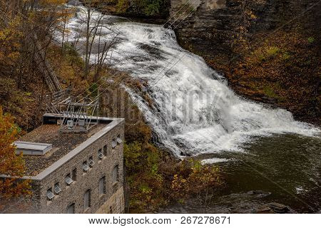 Pedestrian Suspension Bridge Over Triphammer Falls, Ithaca, New York. Waterfall In The Middle Of Cor