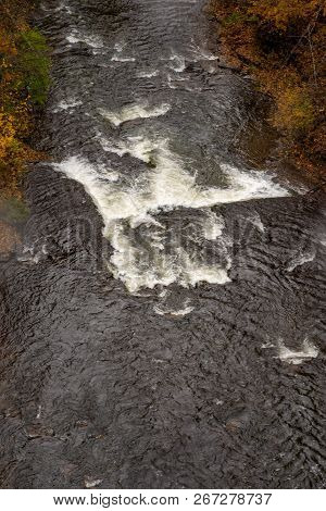 Pedestrian Suspension Bridge Over Triphammer Falls, Ithaca, New York. Waterfall In The Middle Of Cor