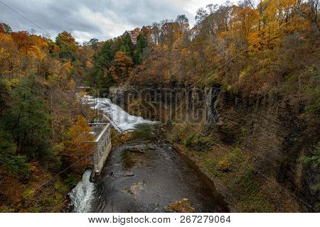 Pedestrian Suspension Bridge Over Triphammer Falls, Ithaca, New York. Waterfall In The Middle Of Cor